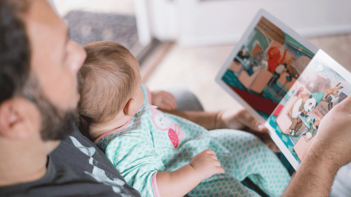 father reading bedtime story to baby